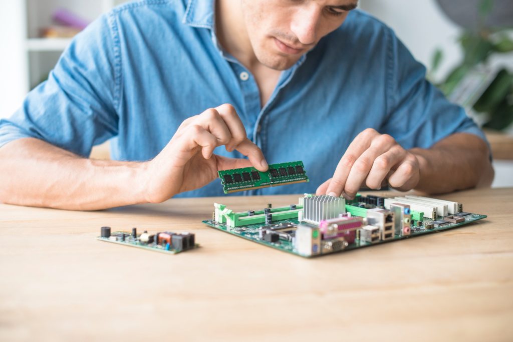 Homem montando placa eletrônica, representando a montagem pth