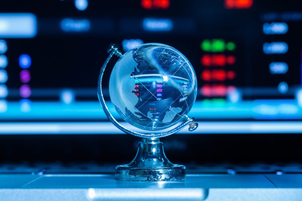 Globo terrestre feito de vidro transparente, com continentes delicadamente marcados, simbolizando fragilidade e conexão global.